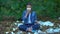 Meditating woman putting on protective mask sitting park landfill, air pollution