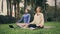 Meditating women online yoga exercises at park. Sport girls sitting lotus pose