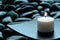 Meditation Candle Burning on Plate over Stones