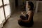 Meditation at home. Young attractive woman in lotus position in front of the window. Relaxation concept
