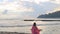 Meditation near the sea and doing yoga on a beach at sunrise