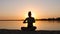 Meditation near the sea and doing yoga on a beach at sunset