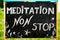 Meditation non stop sign, message written with chalk on blackboard