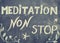 Meditation non stop sign, message written with chalk on blackboard