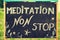Meditation non stop sign, message written with chalk on blackboard
