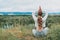 Meditation outside the city in nature. Young woman meditating sitting on the ground. There is a place for copy paste