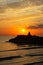 Meditation on the rocks, a man sitting on a rock in the sea at sunset