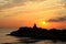 Meditation on the rocks, a man sitting on a rock in the sea at sunset