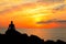 Meditation on the rocks, a man sitting on a rock in the sea at sunset