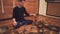 The meditator sits on the floor in a lotus position and plays on Tibetan bowls