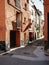 Mediterranean alley. Narrow street between red houses in Cabanes, Spain.