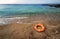 Mediterranean beach, abandoned on the beach an orange ring lifebuoy.