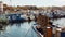Mediterranean dock with small fishing ships and people walking in the distance