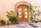 Mediterranean house entrance with flower pots and wood door