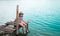 Mediterranean sea background. Alone little girl sitting on pier on beautiful blue lake. clean blue water. Wild nature