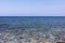 Mediterranean Sea in Northern Cyprus. Summer seashore with transparent blue water and stones background. Seascape. Skyline