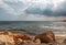 Mediterranean Sea in Northern Cyprus. Summer seashore with transparent blue water sun rays in rain clouds. Seascape. Skyline