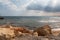 Mediterranean Sea in Northern Cyprus. Summer stone seashore with transparent blue water sun rays in the clouds. Seascape. Storm