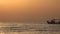 Mediterranean Seascape with a Small Fishing Boat Sailing in a Sunset Red Light