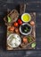 Mediterranean snack - mozzarella, olives, rye ciabatta bread, cherry tomatoes on a rustic cutting board
