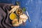 Mediterranean snacks set. Olives, oil, herbs and sliced ciabatta bread on black slate stone board over painted dark blue