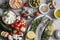 Mediterranean style food background. Fish, vegetables, herbs, chickpeas, olives, cheese on grey background, top view. Healthy food
