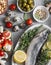 Mediterranean style food. Fish, vegetables, herbs, chickpeas, olives, cheese on grey background, top view. Healthy food concept.