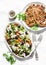 Mediterranean style lunch table - Greek chickpeas salad and pork chops on light background, top view