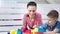 Medium close-up happy adorable mother enjoying playing game toys cubes with little cute son