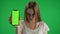 Medium green screen, chroma key shot of a posessed female, woman figure, ghost, poltergeist, zombie holding a smartphone