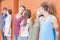 Medium group of people kissing and standing near red wall background