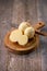 Medium hard cheese head scamorza on wooden board with knife wooden texture daylight