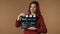 Medium isolated shot satisfied, happy and relaxed young woman holding a closed movie clicker, slate, clapperboard in