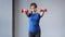 Medium long shot smiling Asian sports woman doing exercise lifting dumbbells in front of herself