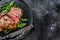 Medium rare sliced grilled striploin beef steak or new york steak. Black background. Top view. Copy space