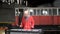 Medium shot of attractive Man playing the vibraphone in red outfit - Old train repair factory
