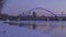 A medium shot of the blue lowry bridge and distant Minneapolis skyline reflecting in the half frozen Mississippi River during a Wi