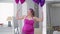 Medium shot of funny obese woman raising balloons imitating weight lifting looking at camera. Portrait of relaxed