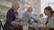 Medium shot of middle aged ceramic artist teaching group elderly Caucasian woman and senior man how to wedge clay