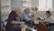 Medium shot of middle aged ceramic artist teaching group elderly Caucasian woman and senior man how to wedge clay