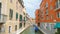 Medium shot of people along Venetian canal.