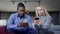 Medium shot portrait of absorbed interracial couple using smartphones sitting in living room. Device addicted African