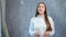 Medium shot portrait of beautiful European speaker woman talking at studio gray background