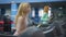 Medium shot portrait of beautiful young Caucasian slim woman jogging on treadmill as blurred redhead sportswoman