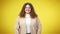 Medium shot portrait of cheerful overweight young Caucasian woman posing at yellow background. Positive beautiful