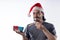 Medium shot portrait of smiling Latino man with red Santa Claus hat.