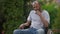 Medium shot portrait of thoughtful African American man sitting in wheelchair outdoors. Adult sad disabled guy thinking