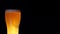 Medium shot stream of fresh cold beer beverage pouring into full big glass slowmo