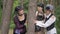 Medium shot three smiling women hugging tree looking at camera. Beautiful Caucasian ladies in Halloween steampunk