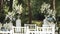 Medium shot wedding arch decorated with pastel faded flowers and white chairs lake on the background, slow motion shot